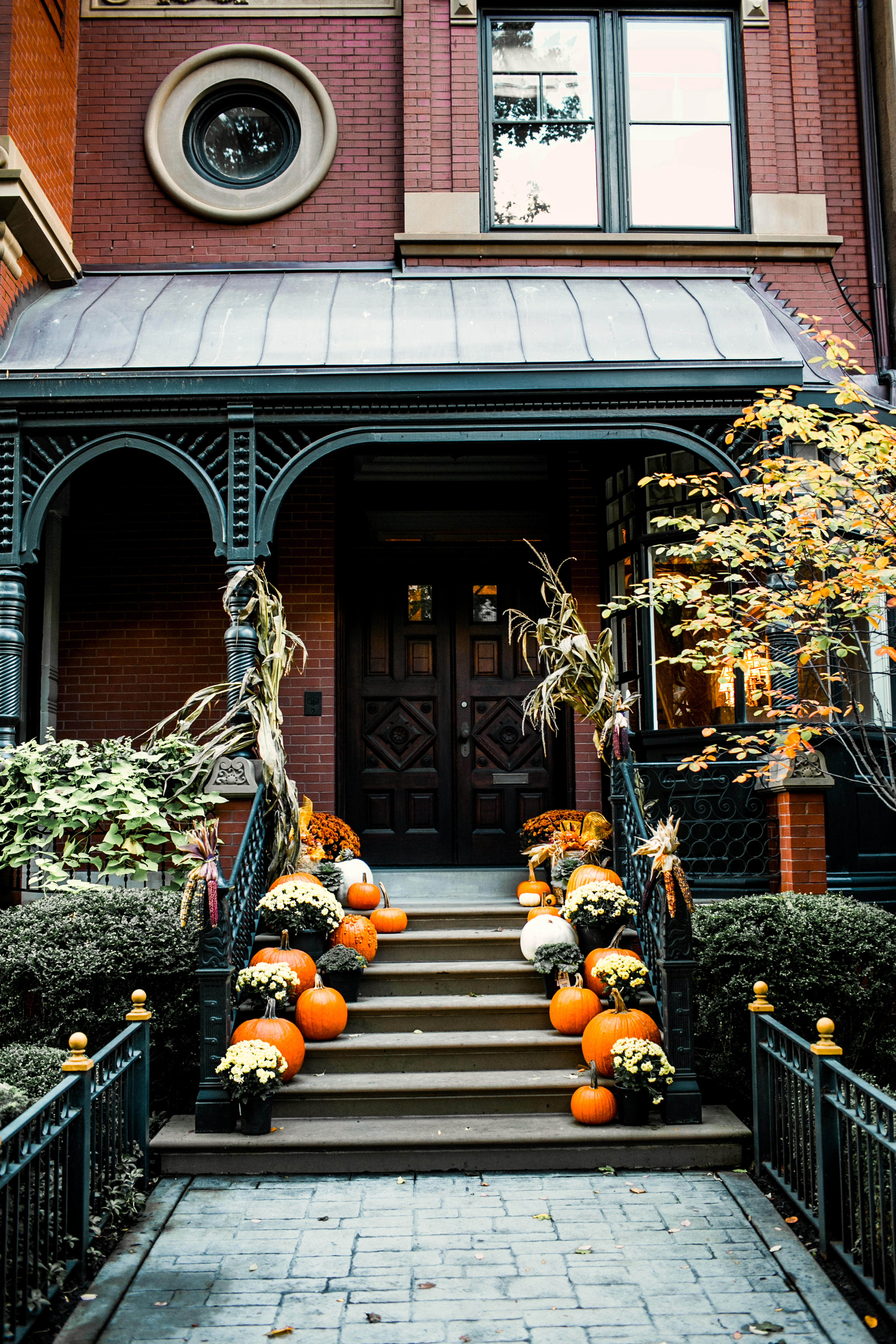 A beautiful stoop filled with pumpkins and mums.