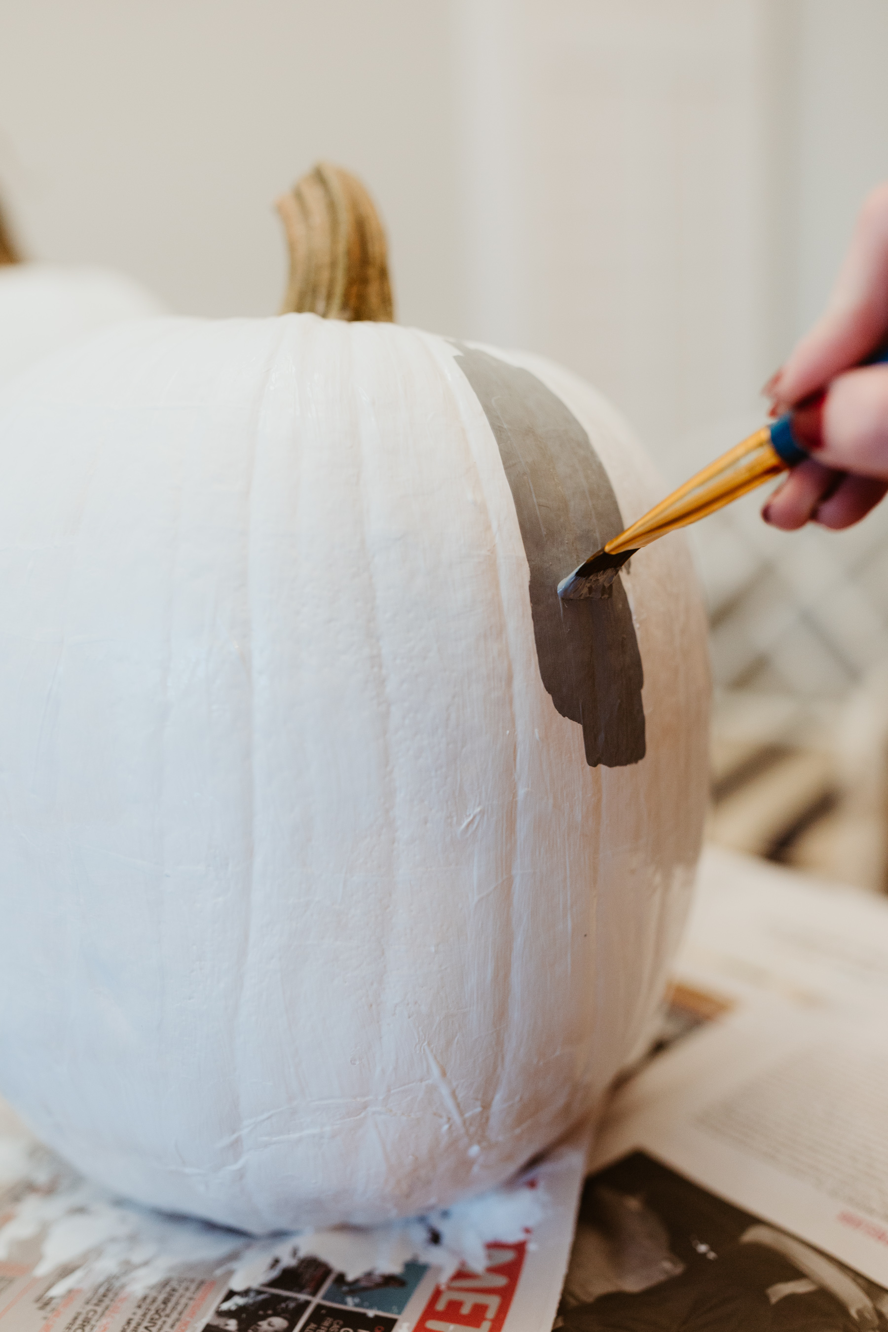 Buffalo plaid pumpkin: Start by painting the pumpkin white. We used acrylic paint we found on Amazon.