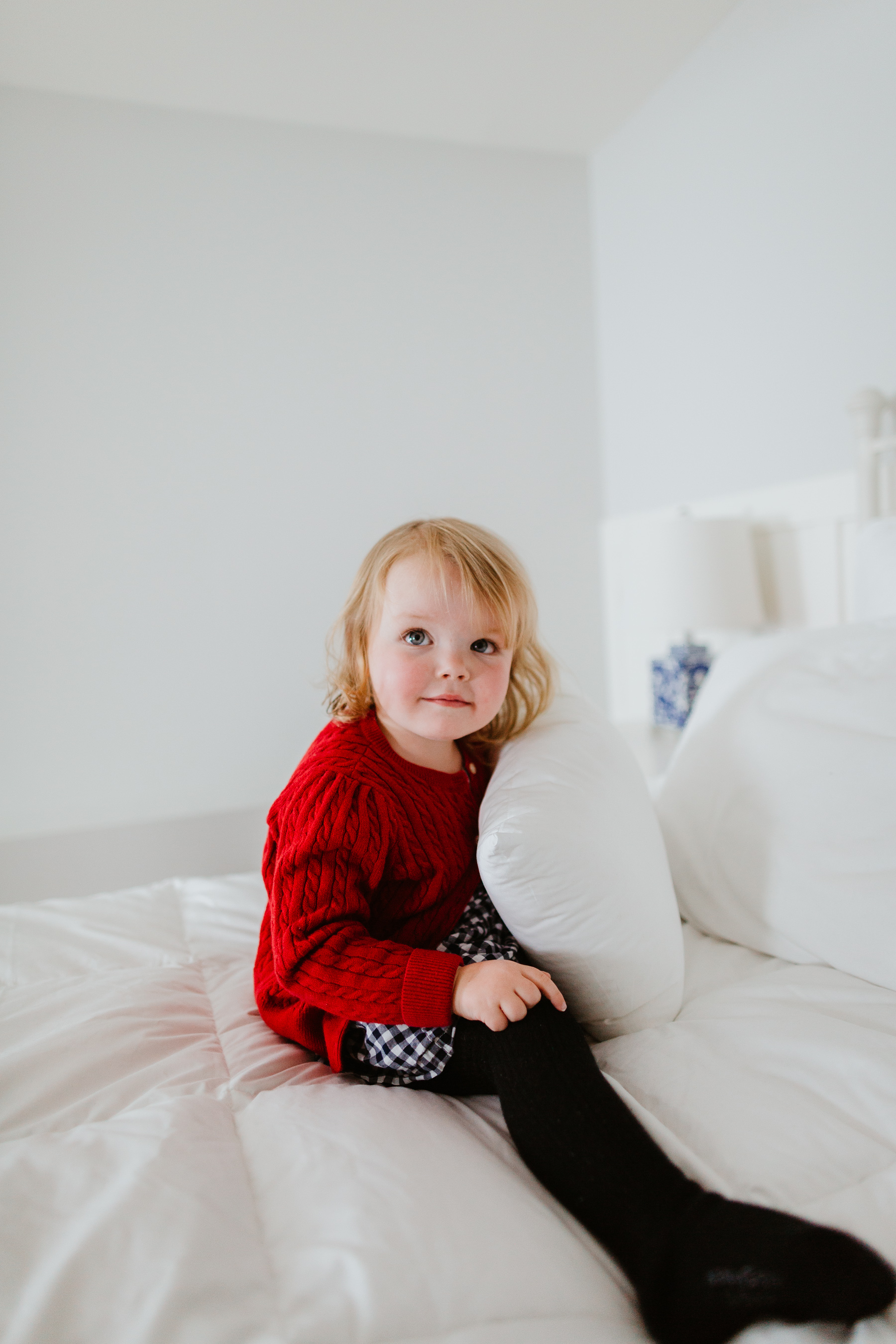 Emma Larkin is wearing a red sweater and a gingham skirt.