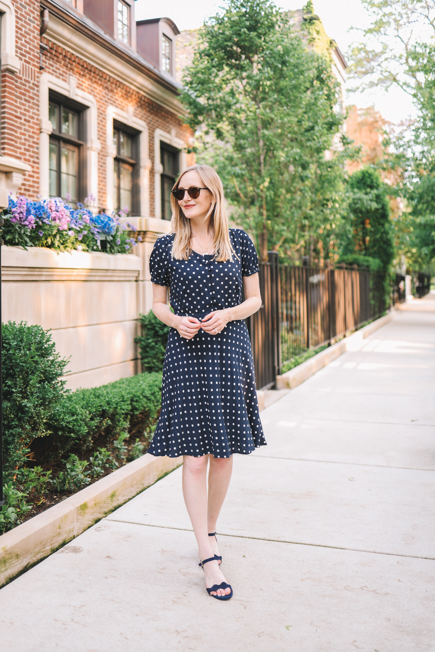 Kelly Larkin's outfit details: Navy Polka Dot Dress / Patricia Green Scalloped Sandals 