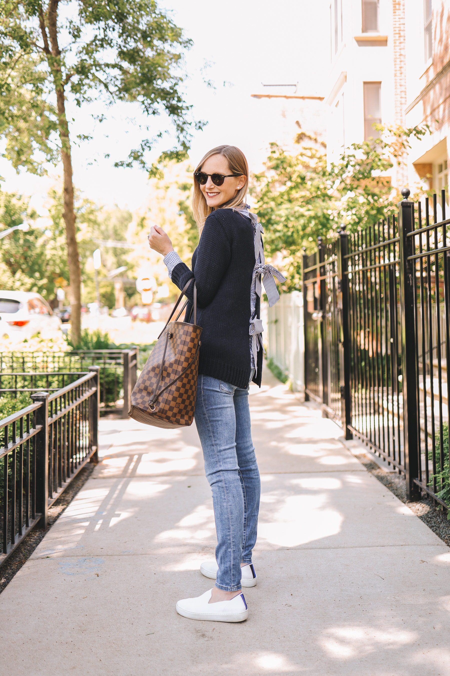 Kely's outfit details: Maternity Jeans / Rothy's Washable Sneakers / Tuckernuck Bow Sweater / J.McLaughlin Gingham Button-Down / Louis Vuitton Neverfull GM /  Ray-Ban Sunglasses