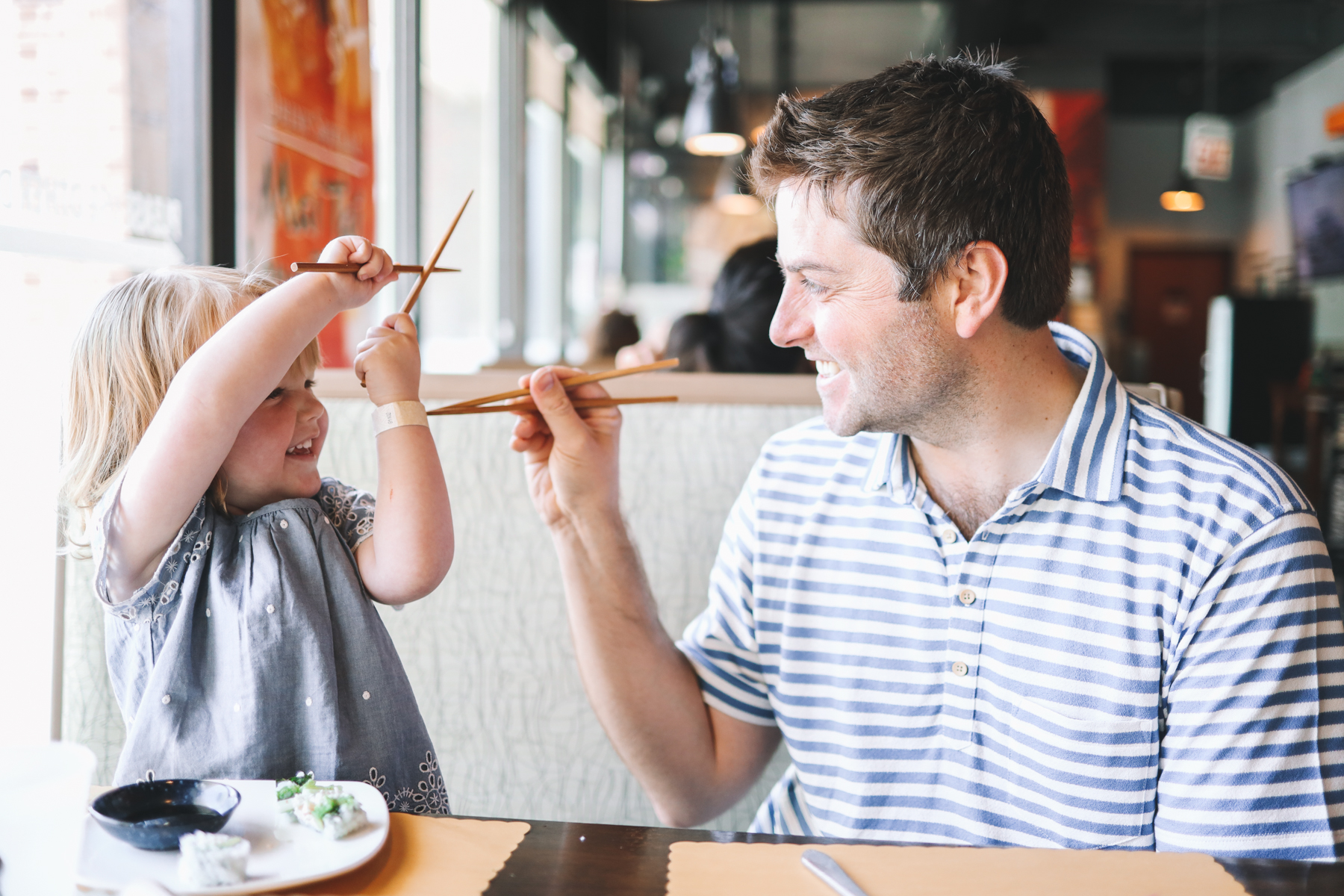 Father and daughter are eating sushi