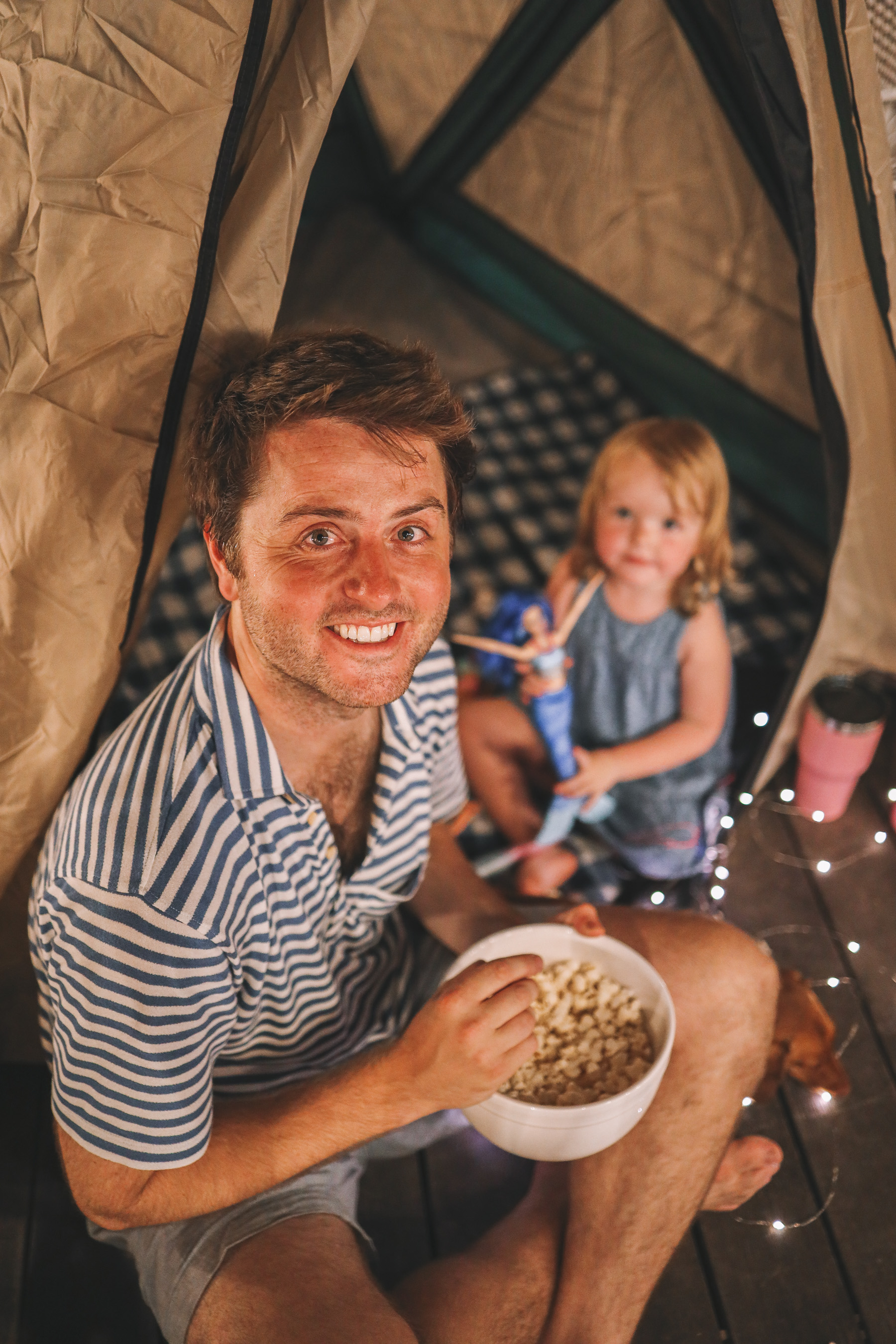 man eating popcorn with his daugther