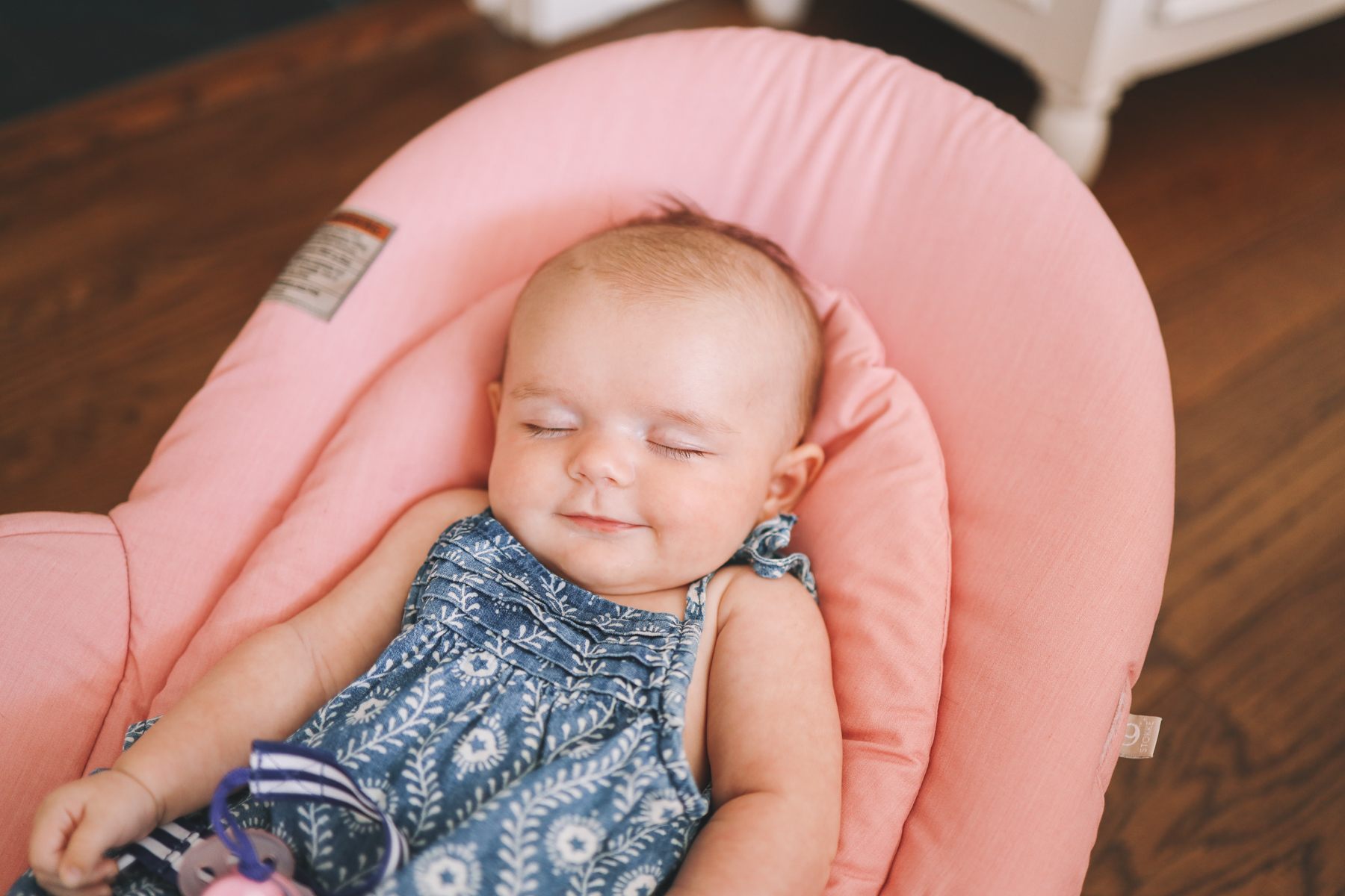 A sleeping Lucy in her pink baby chair
