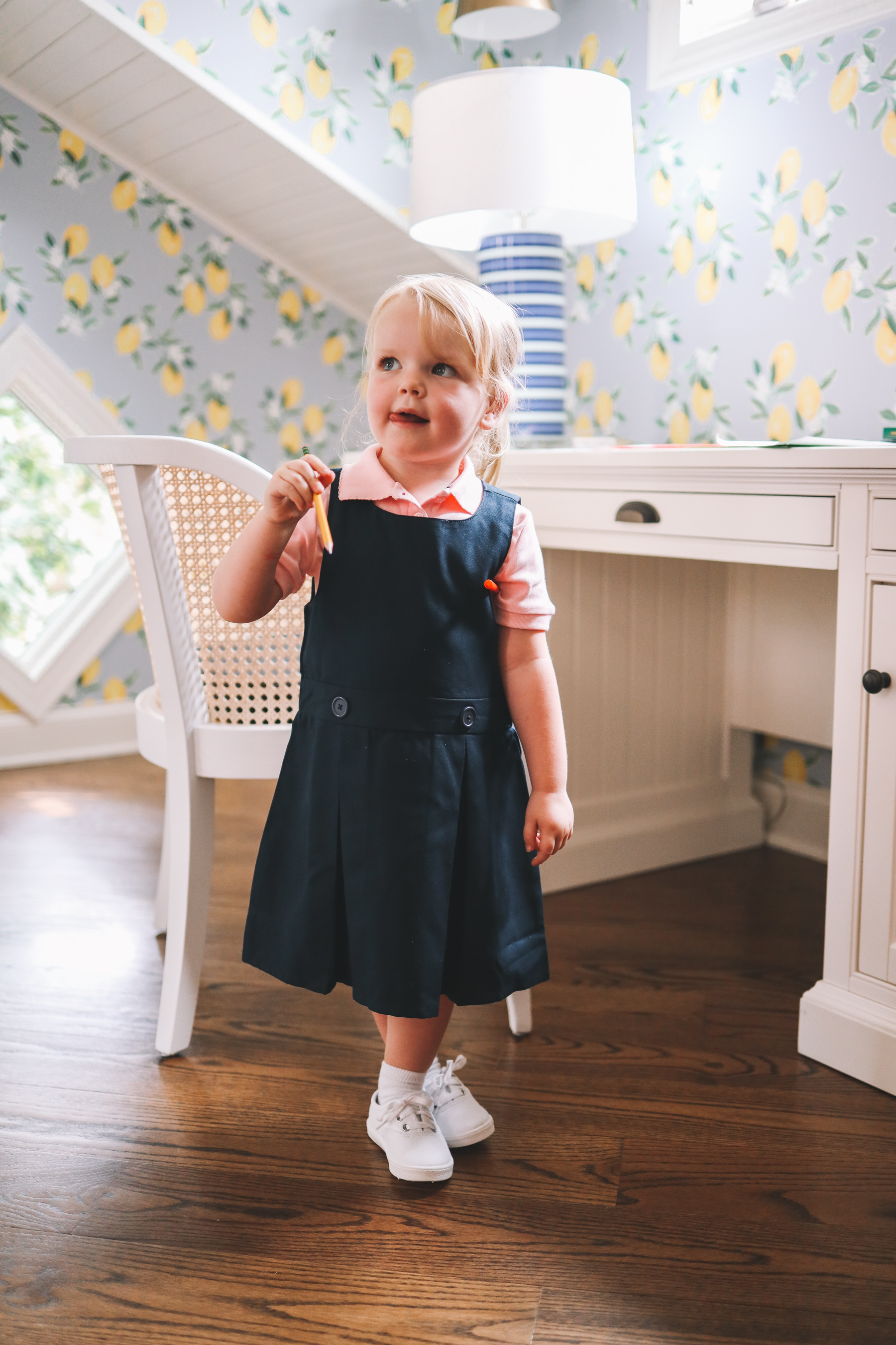 a little girl pointing to a school supply list