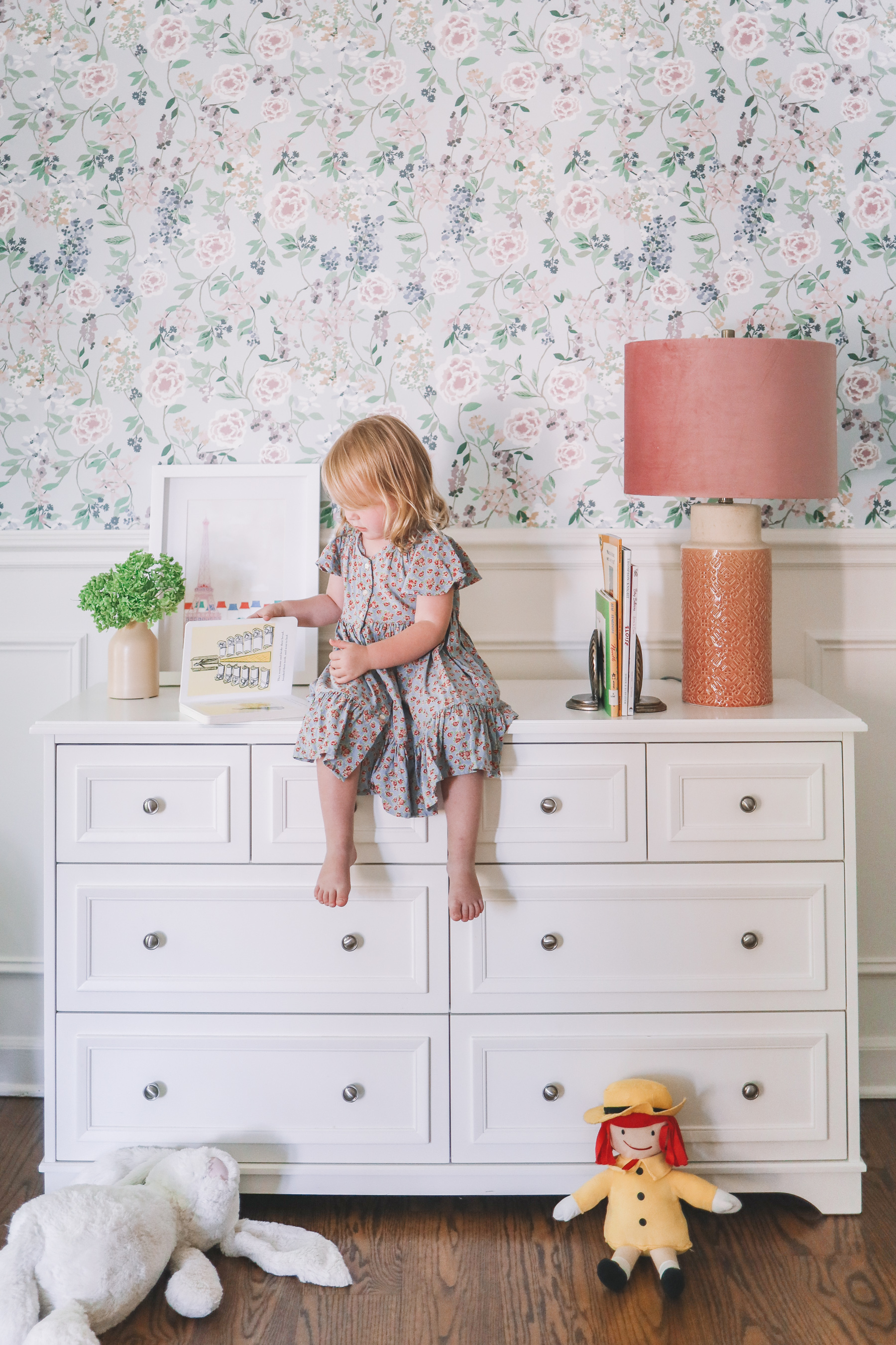 flower home of this little girl who is sitting on a dresser