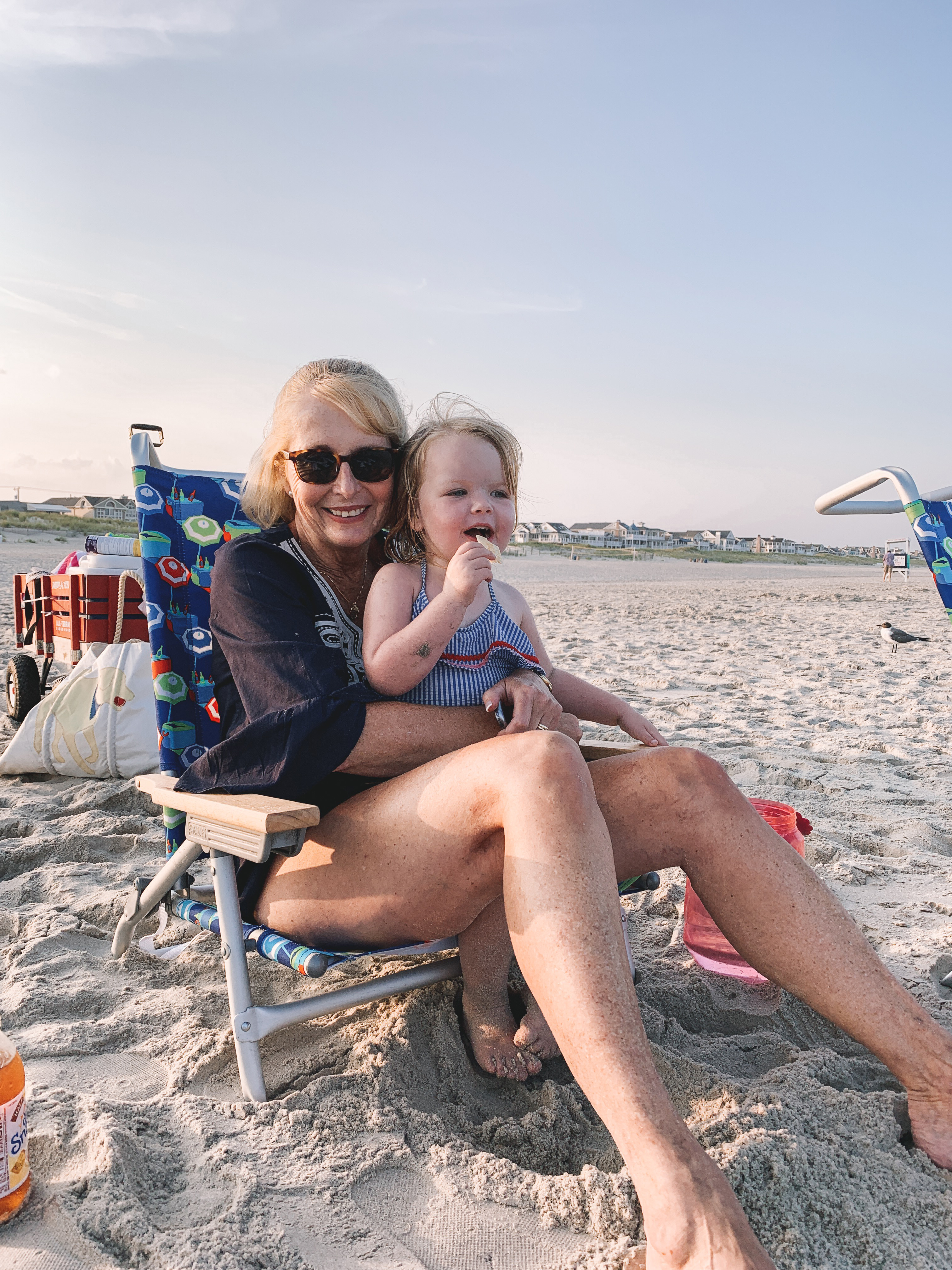 A grandma holding her granddaughter in jersey at sunset