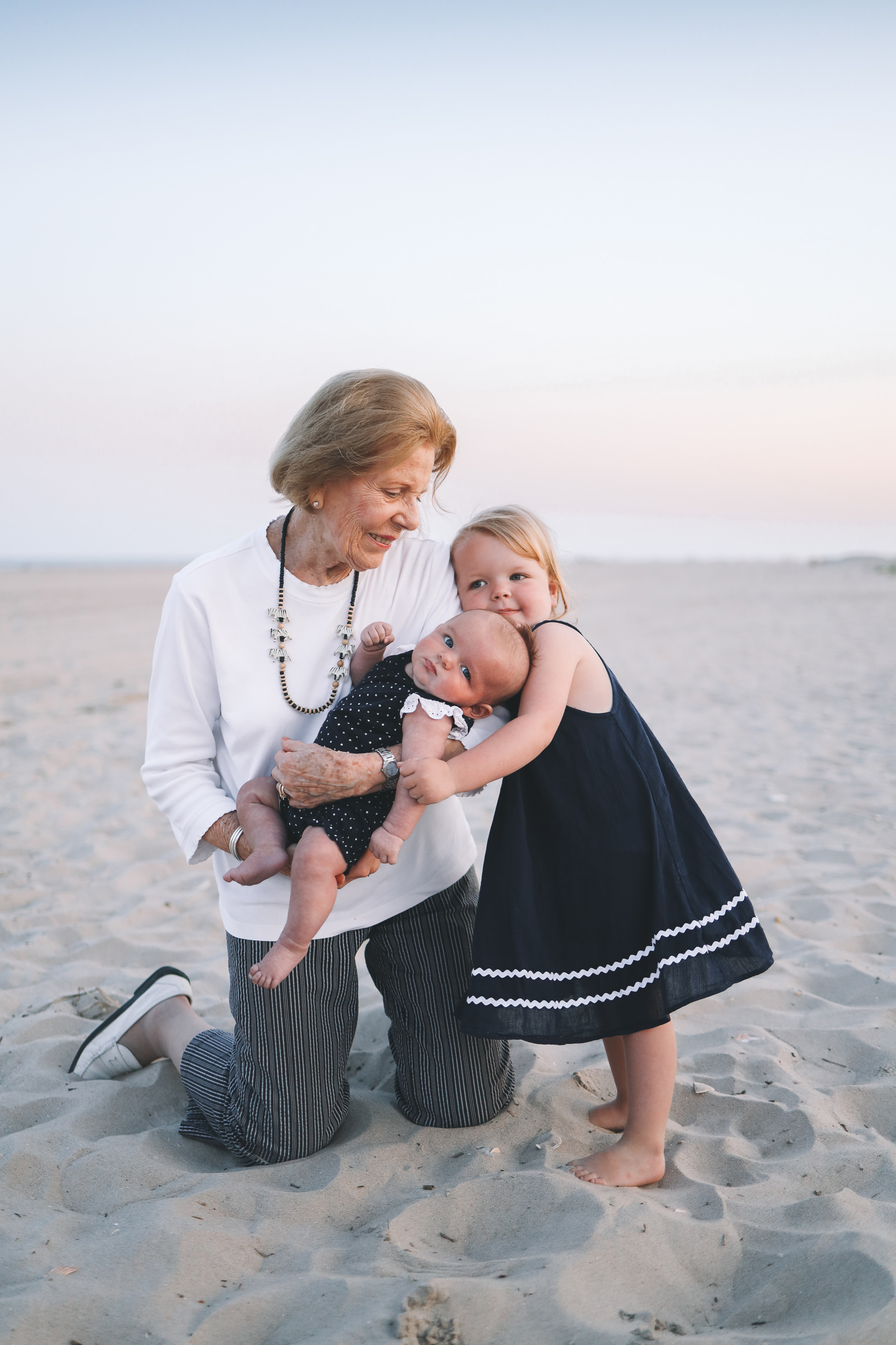 so much love with relatives on the beach as they smile for family Christmas card photos