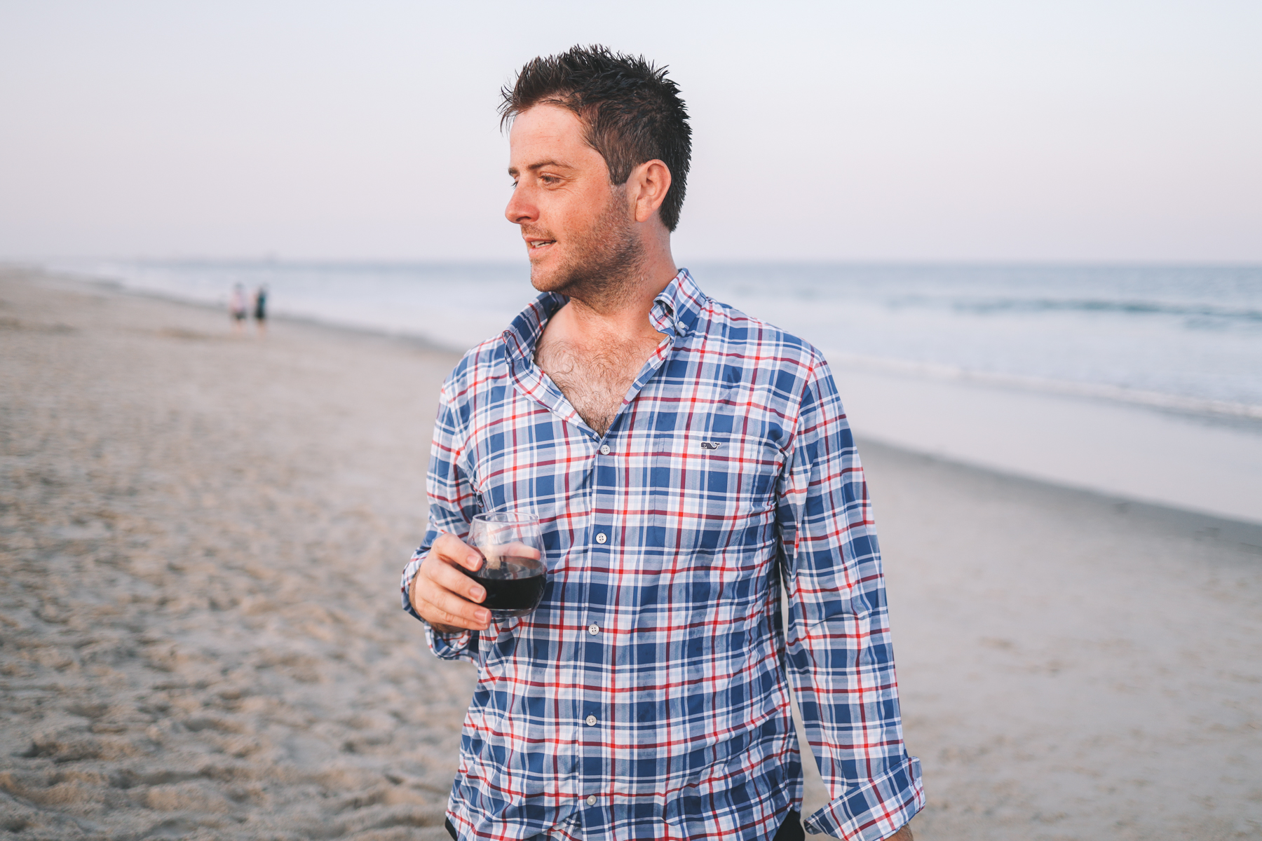 Mitch drinking from a wine glass on the beach