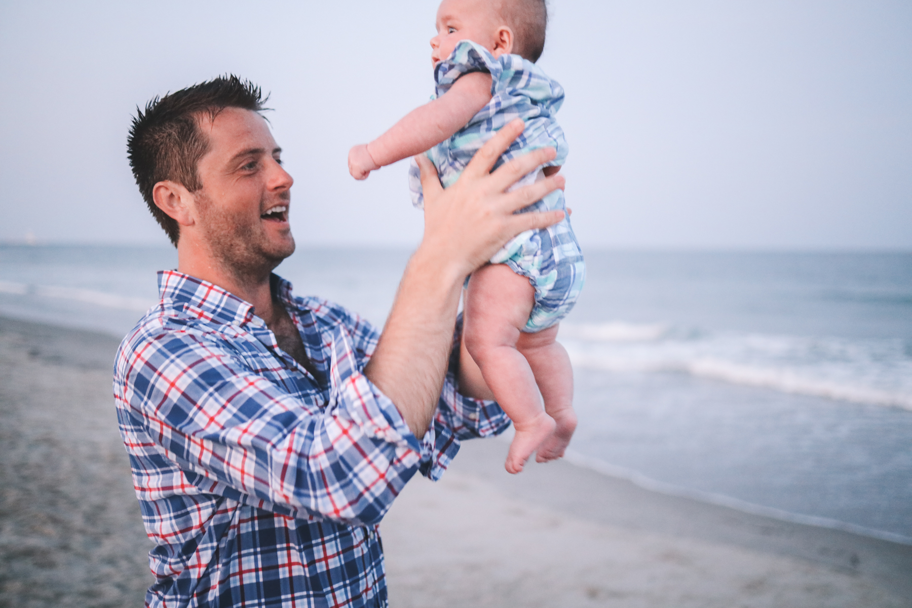Mitch holds the baby at the beach