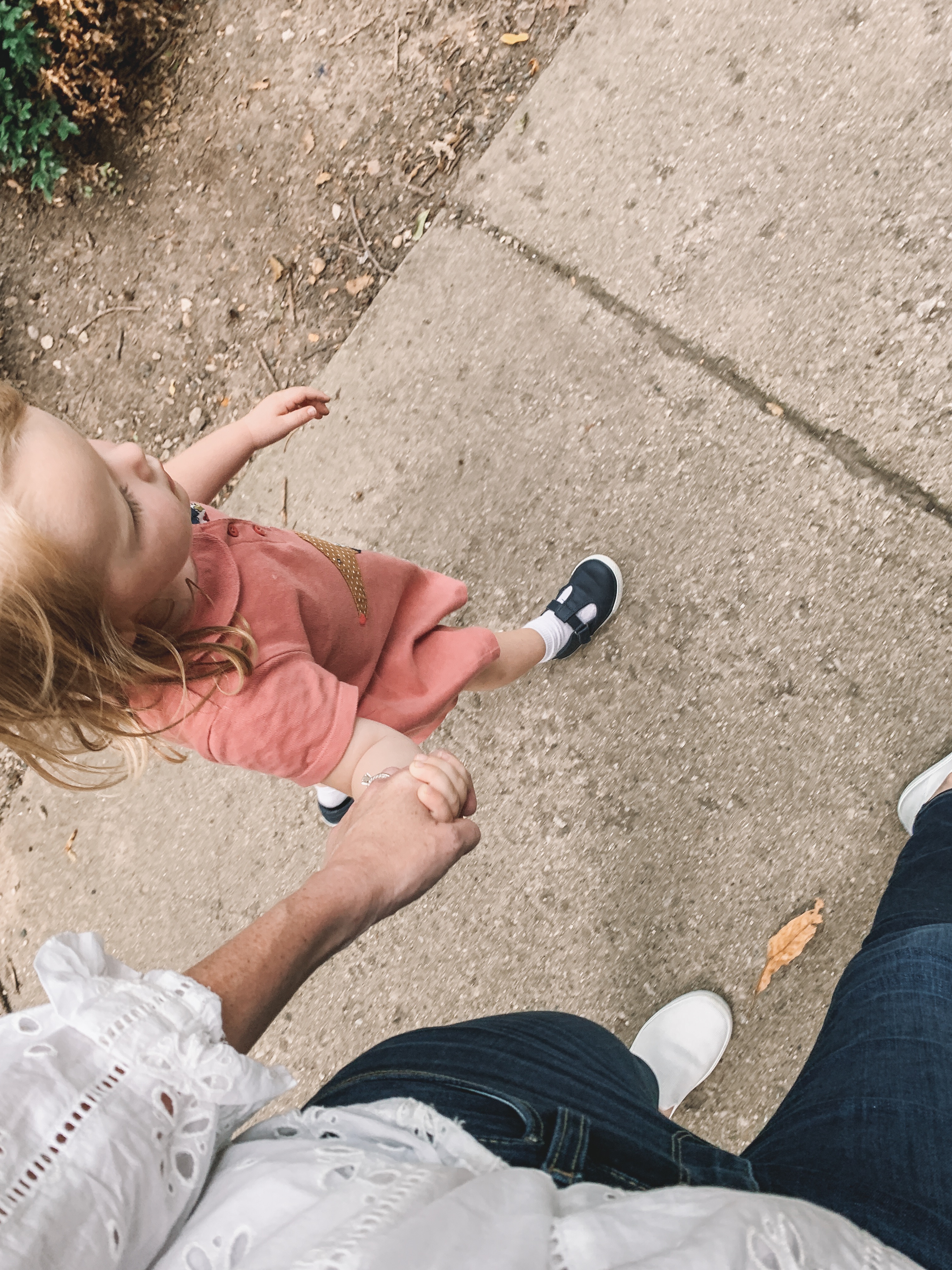 a child holding the hand of a mom