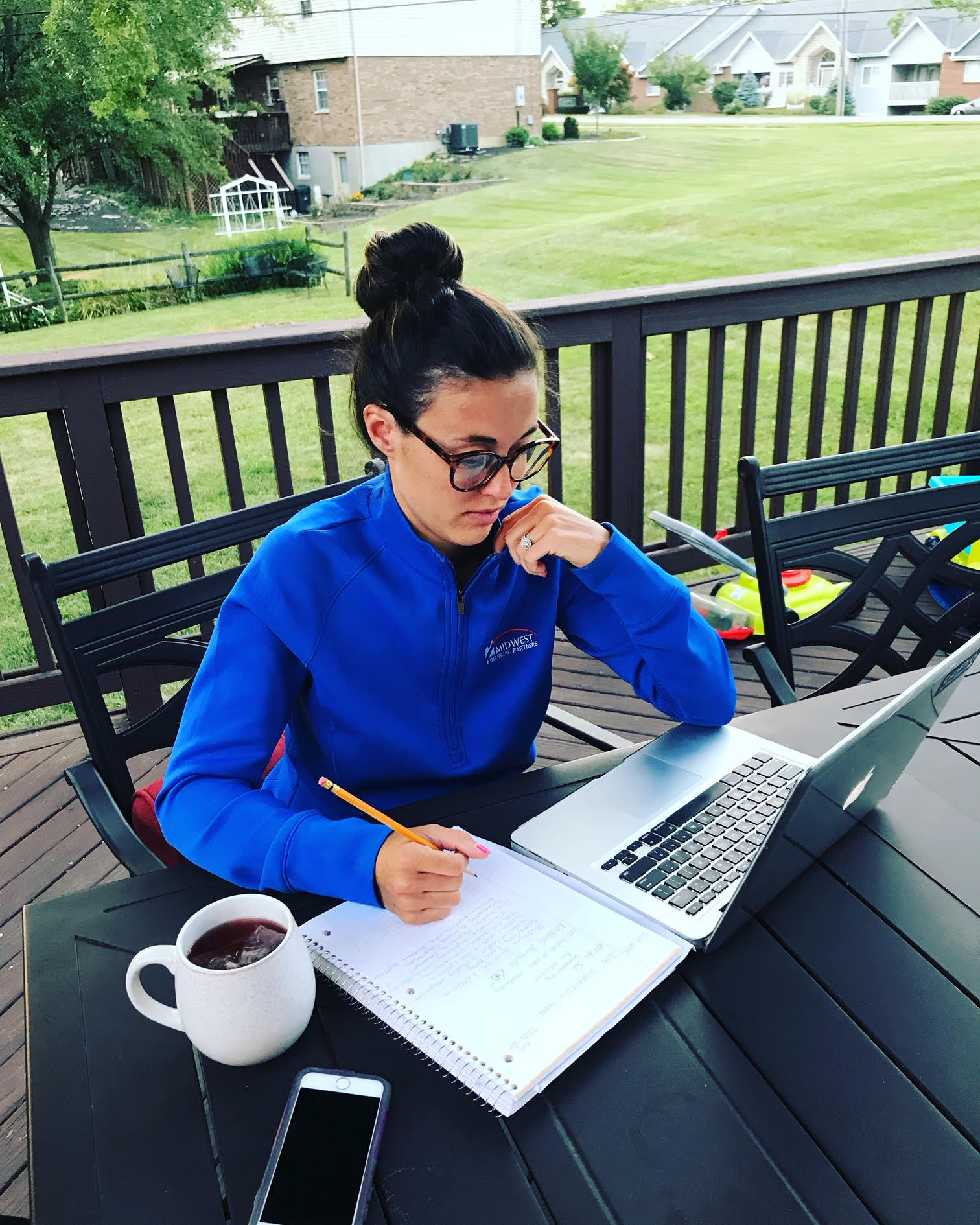 a person sitting at a laptop with a tea next to her