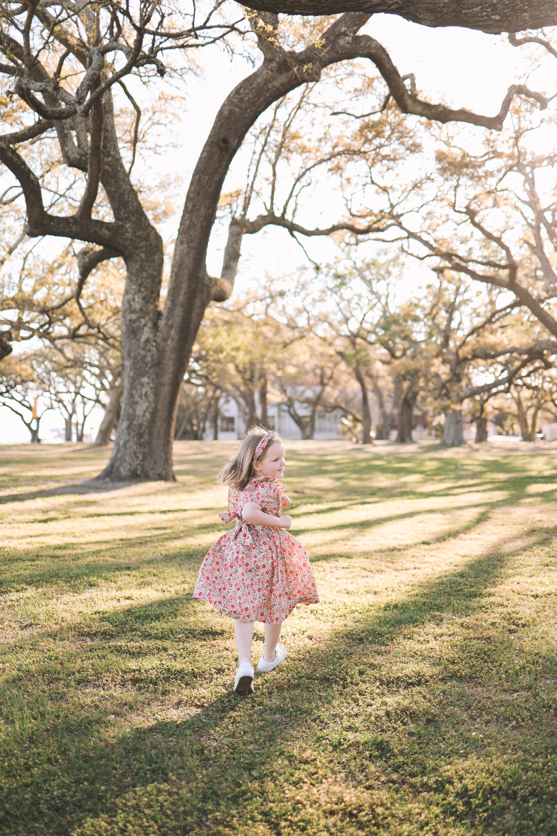 child running around under oak trees