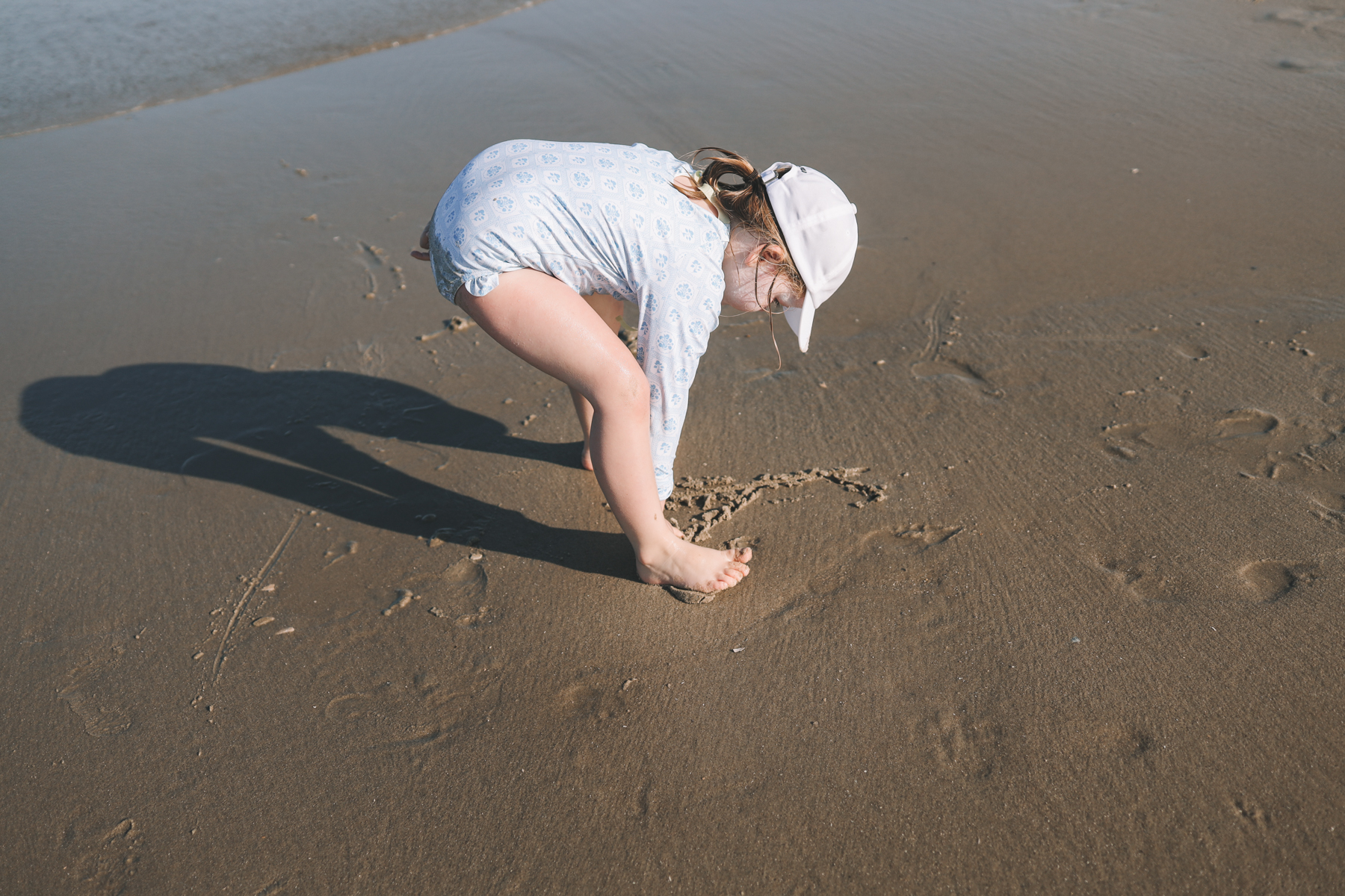 Toddler writing on sand