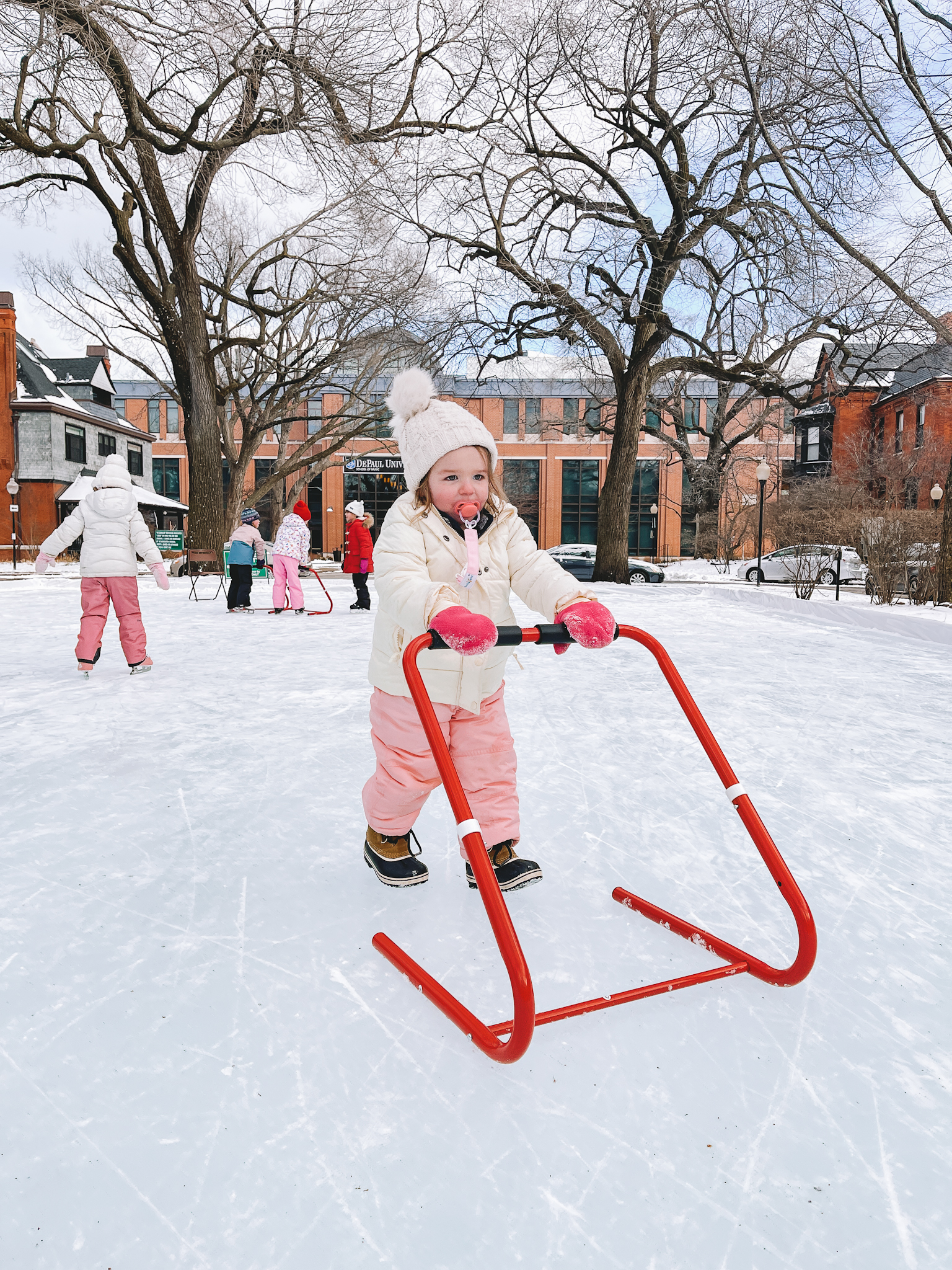 toddler pushing ice skating trainer