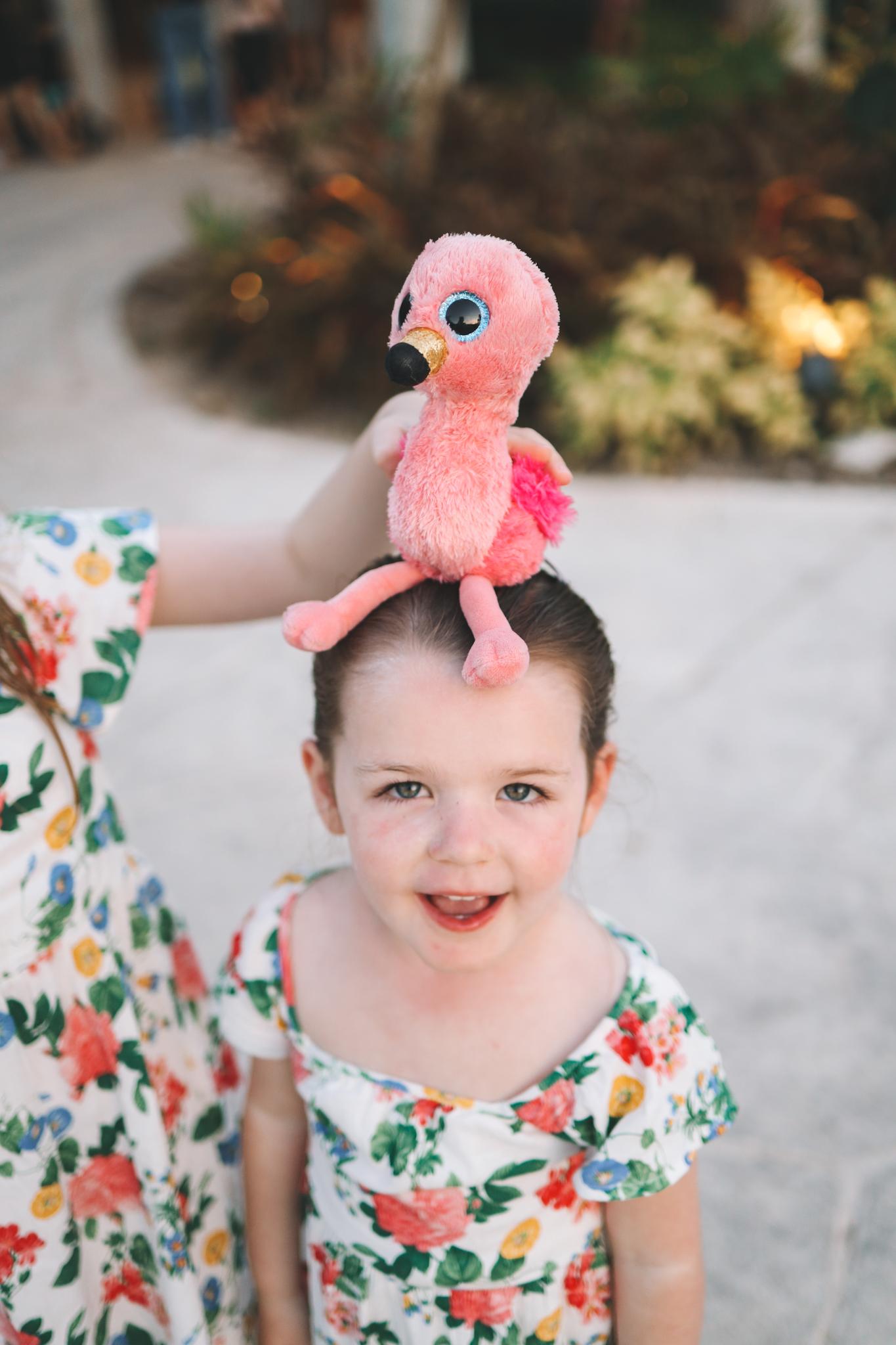 stuffed flamingo on top of Lucy's head